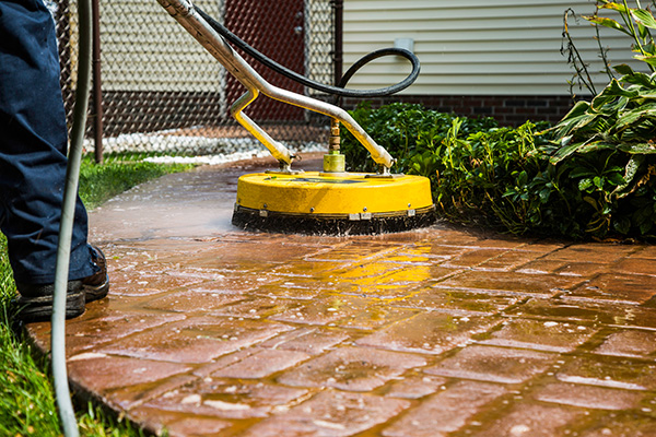 Surface cleaner being used for patio power washing on brick.